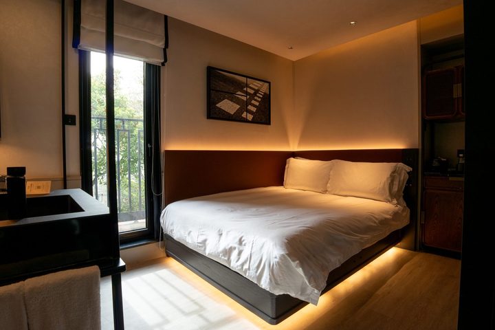 Habitación de hotel con la cama sobre un zócalo iluminado