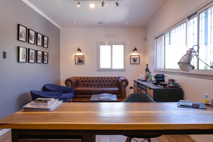 Oficina con sillón chesterfield de cuero y mesa de madera