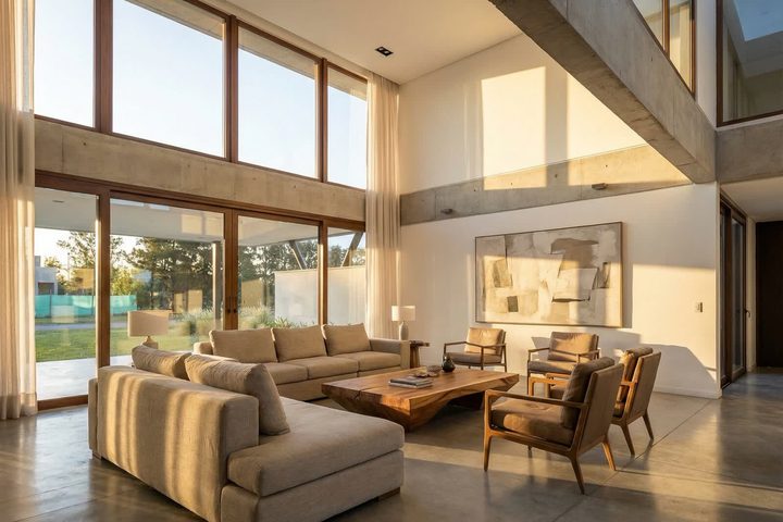 Render de un living de doble altura con luz de tarde